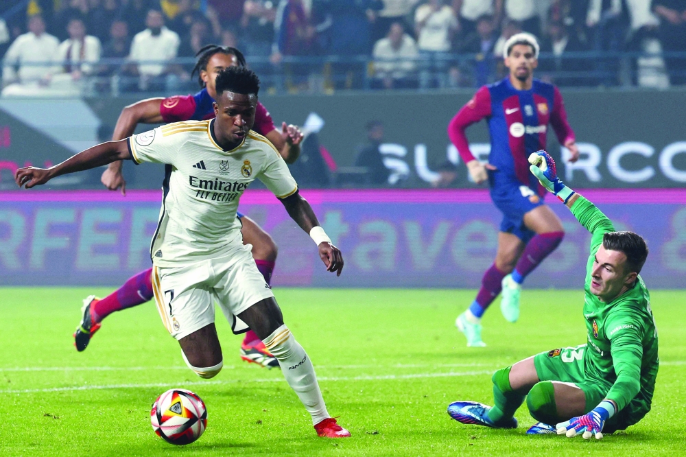 TOPSHOT - Real Madrid's Brazilian forward #07 Vinicius Junior runs with the ball before scoring his second goal during the Spanish Super Cup final football match between Real Madrid and Barcelona at the Al-Awwal Park Stadium in Riyadh, on January 14, 2024.