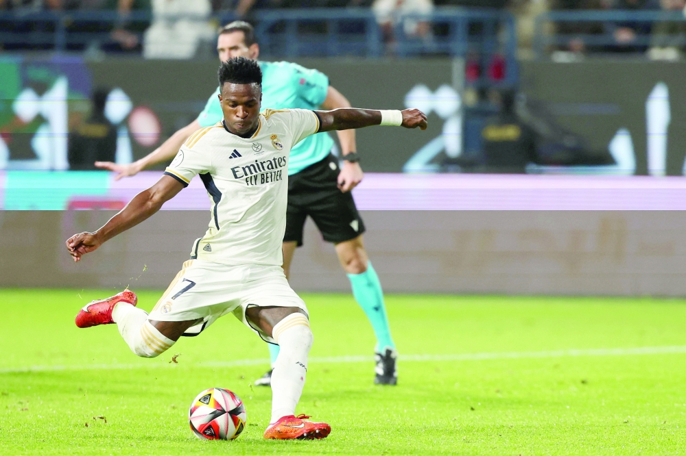 Real Madrid's Brazilian forward #07 Vinicius Junior shoots a penalty to score his third goal during the Spanish Super Cup final football match between Real Madrid and Barcelona at the Al-Awwal Park Stadium in Riyadh, on January 14, 2024. 