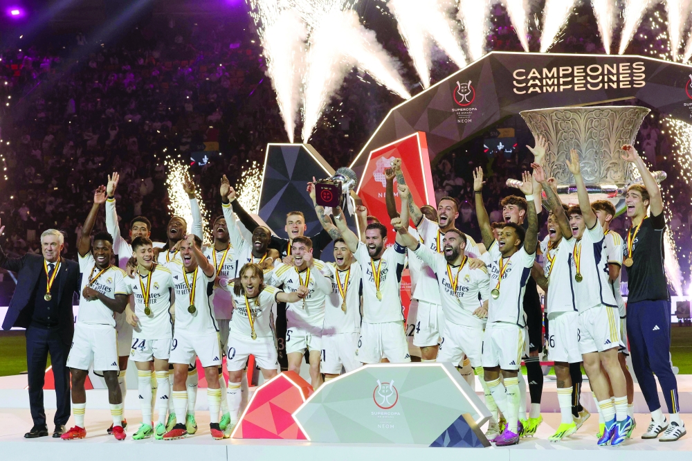 TOPSHOT - Real Madrid's Spanish defender and captain #06 Nacho Fernandez lifts the trophy as he celebrates with his teammates after winning the Spanish Super Cup final football match against Barcelona at Al-Awwal Park Stadium in Riyadh, on January 14, 2024.