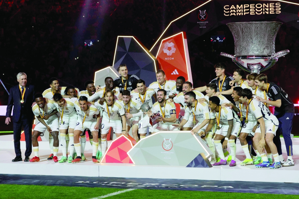 Real Madrid's Spanish defender and captain #06 Nacho Fernandez holds the trophy as he celebrates with his teammates after winning the Spanish Super Cup final football match against Barcelona at Al-Awwal Park Stadium in Riyadh, on January 14, 2024.