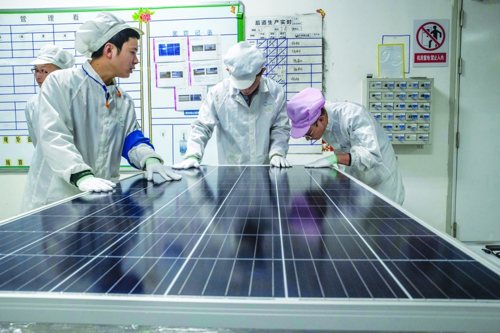 Workers perform a quality check on a solar panel production line at a factory in Suzhou, China, on Jan. 10, 2019.  (Gilles Sabri