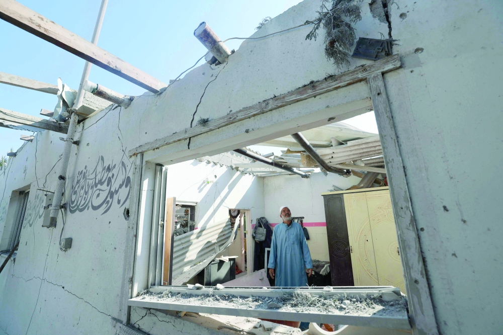 A Palesitinian man inspects his damaged home on the southern outskirts of Khan Yunis. — AFP 