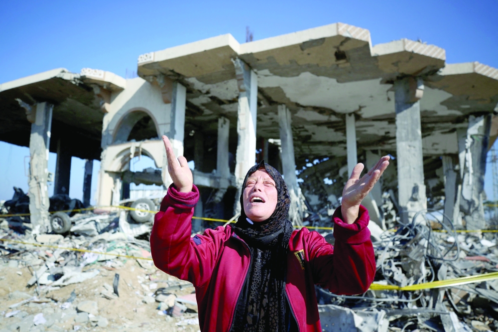 A Palestinian woman reacts in front of a destroyed building in the Al-Maghazi refugee camp in central Gaza Strip. — AFP