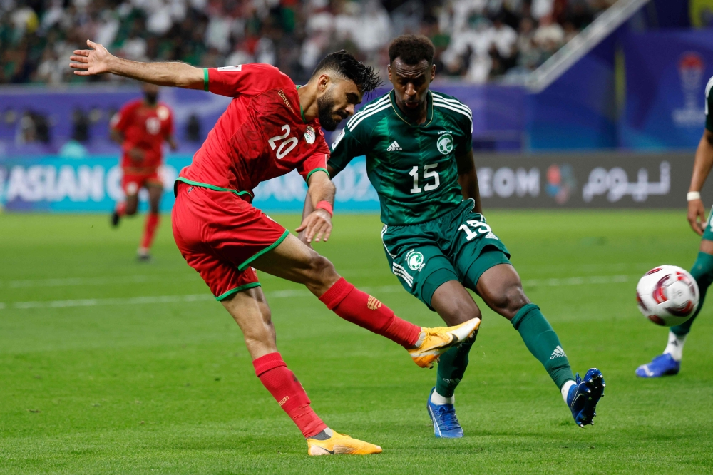 Oman's midfielder #20 Salaah al-Yahyaei attempts a shot as he is marked by Saudi Arabia's midfielder #15 Abdullah al-Khaibari during the Qatar 2023 AFC Asian Cup Group F football match between Saudi Arabia and Oman at the Khalifa International Stadium in Doha on January 16, 2024.  (Photo by KARIM JAAFAR / AFP)

