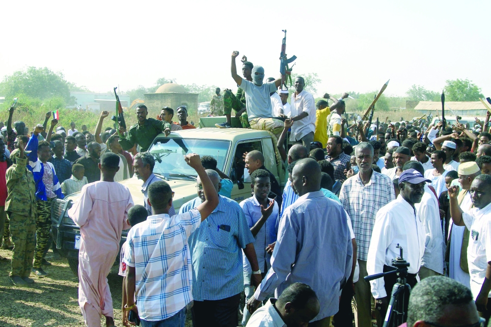 Sudanese supporters and members of the Sudanese armed popular resistance raise their weapons on a pick-up truck, in Gedaref, Sudan. — AFP
