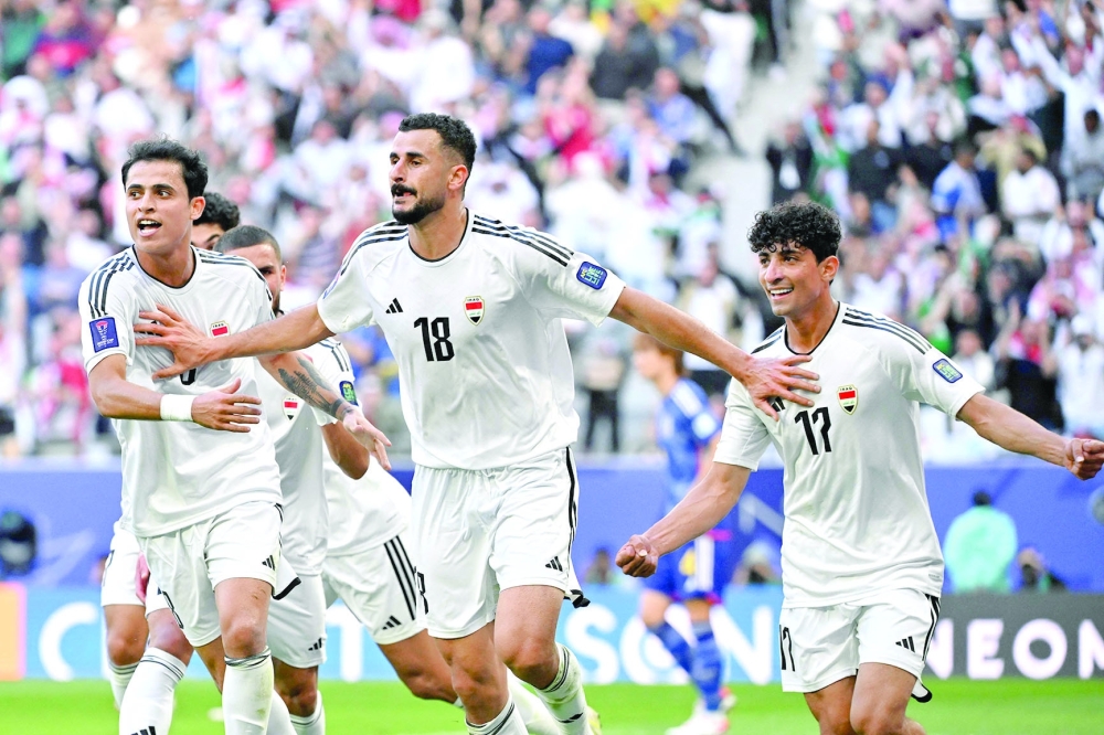 Iraq's forward #18 Aymen Hussein celebrates with team-mates after scoring his team's second goal during the Qatar 2023 AFC Asian Cup Group D football match between Iraq and Japan at the Education City Stadium in Al Rayyan, west of Doha on January 19, 2024.  (Photo by HECTOR RETAMAL / AFP)