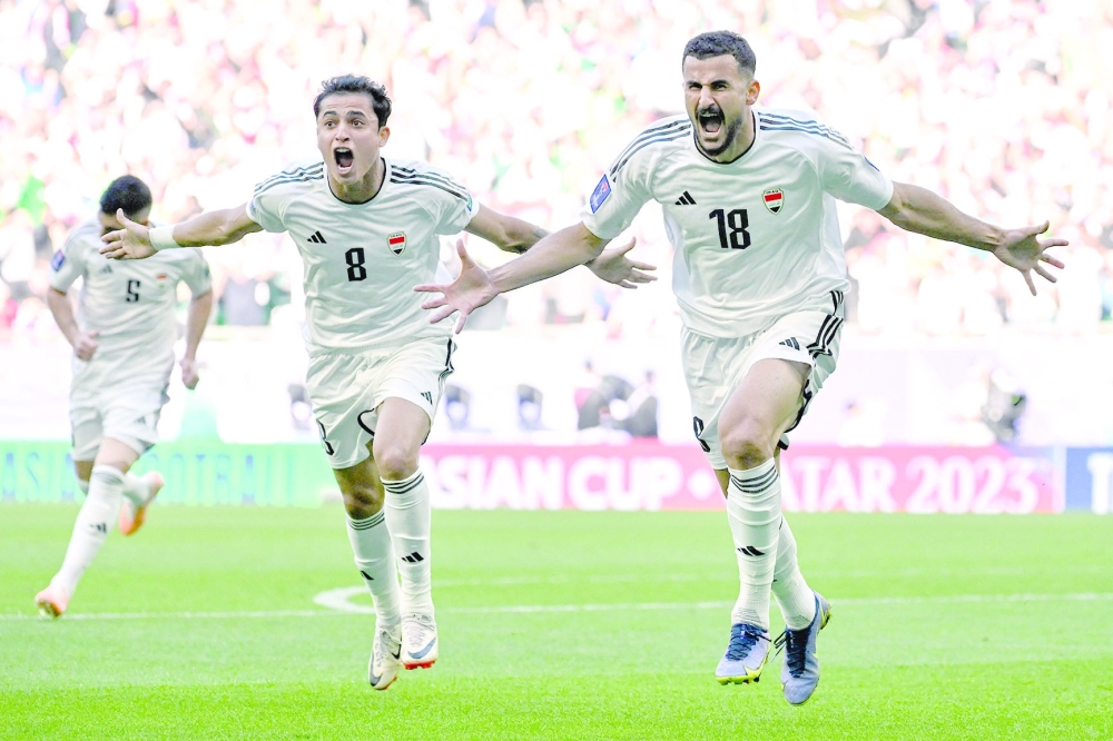 Iraq's forward #18 Aymen Hussein celebrates with team-mates after scoring his team's first goal during the Qatar 2023 AFC Asian Cup Group D football match between Iraq and Japan at the Education City Stadium in Al Rayyan, west of Doha on January 19, 2024.  (Photo by HECTOR RETAMAL / AFP)