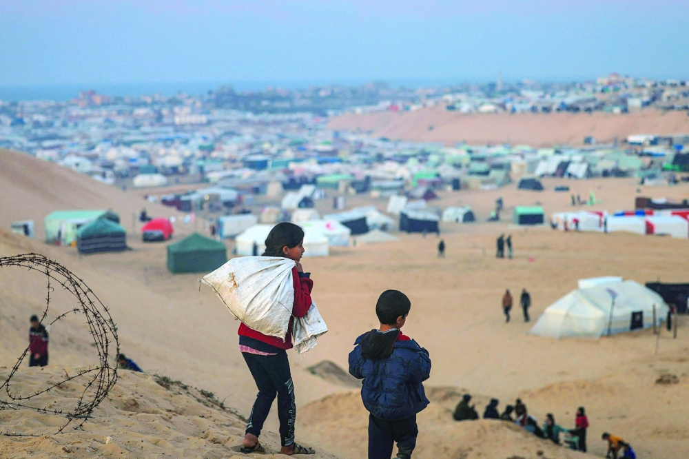 Displaced Palestinian children walk on a hill facing their makeshift camp in Rafah, on the southern Gaza Strip. — AFP 