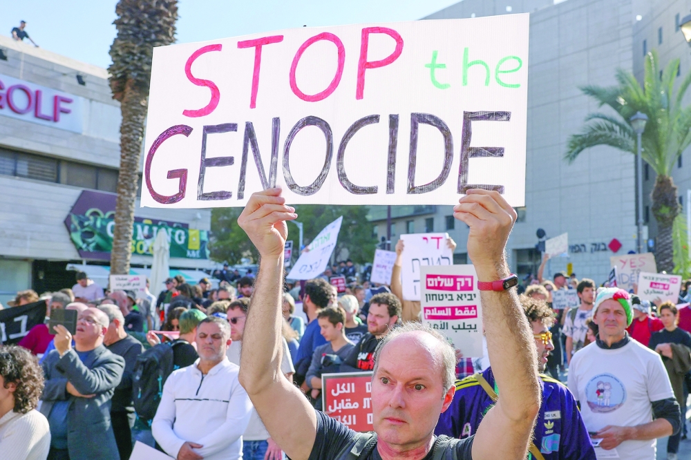 People hold placards as they take part in a protest calling for a ceasefire and for the release of Israeli captives, in the northern port city of Haifa. — AFP 