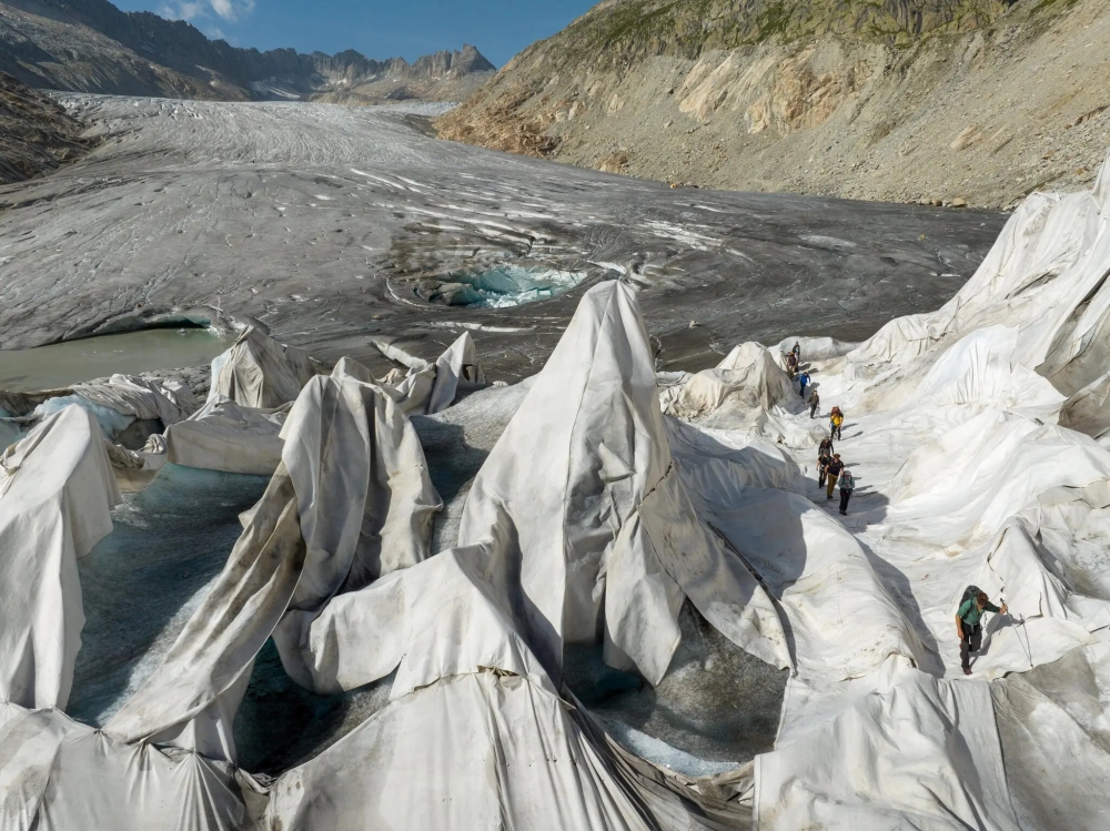 Tarps are used to slow melting on part of the Rhône Glacier. Melting has revealed previous years of pollution, turning the glacier black, which in turn speeds the melting.
