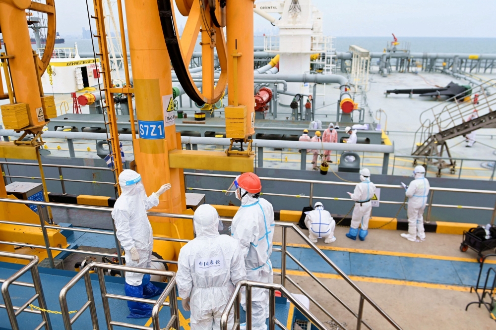 Immigration inspection officers check a tanker carrying imported crude oil at the port in Qingdao, Shandong, China. — Reuters
