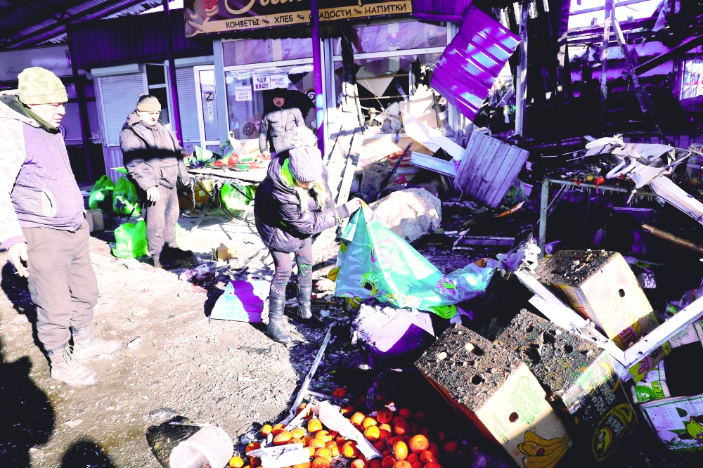 People remove debris at a food market following a Ukrainian military strike in the course of Russia-Ukraine conflict in Donetsk. — Reuters