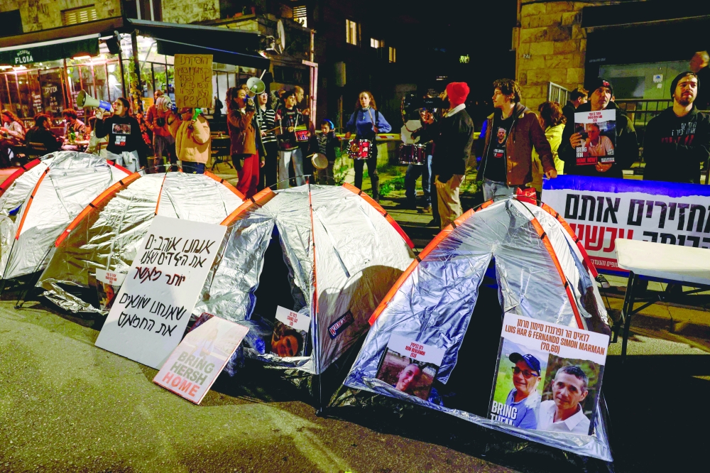 Protesters stand behind tents during a rally organised by family and supporters of Israeli captives held in Gaza. — AFP