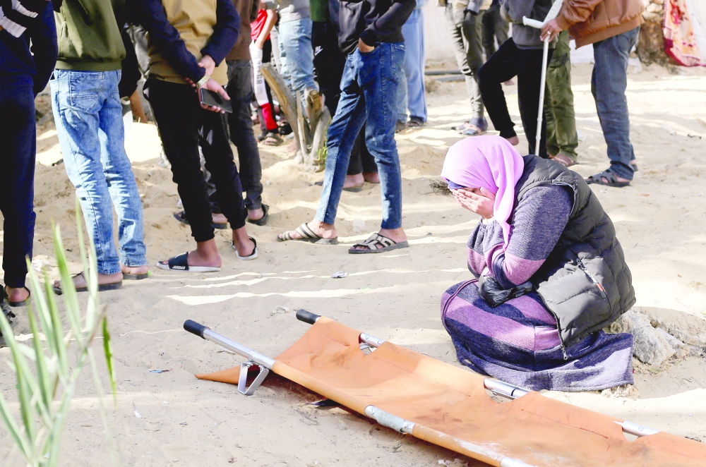 A woman reacts while people bury bodies of Palestinians killed in an Israeli strike, at the Nasser hospital premises as Palestinians cannot reach the cemetery due to the Israeli ground operation, in Khan Younis. — Reuters 