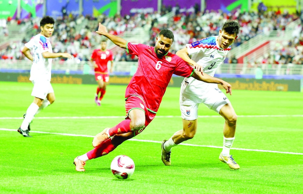 Oman's Ahmed al Khamisi in action with Thailand's Supachai Chaided — REUTERS