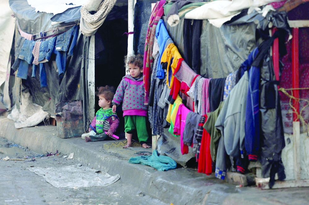 Children stand outside tents at a makeshift tent camp housing displaced Palestinians in Rafah. — AFP