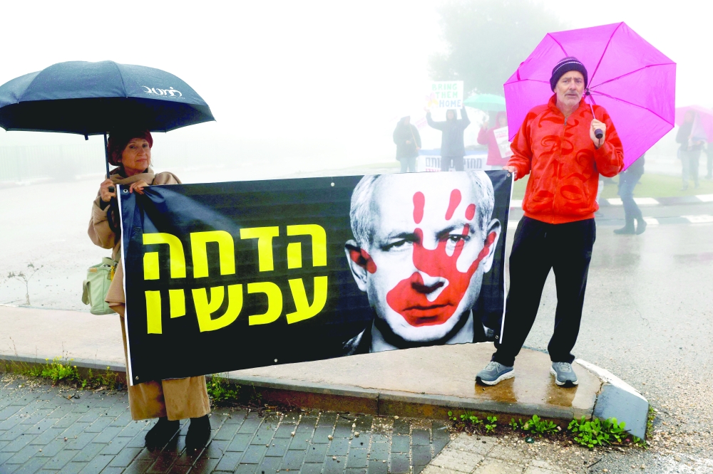 Israeli protesters hold a banner featuring Prime Minister Benjamin Netanyahu during an anti-government rally outside Ramat Chorazim school in Moshav Elifelet in northern Israel. — AFP