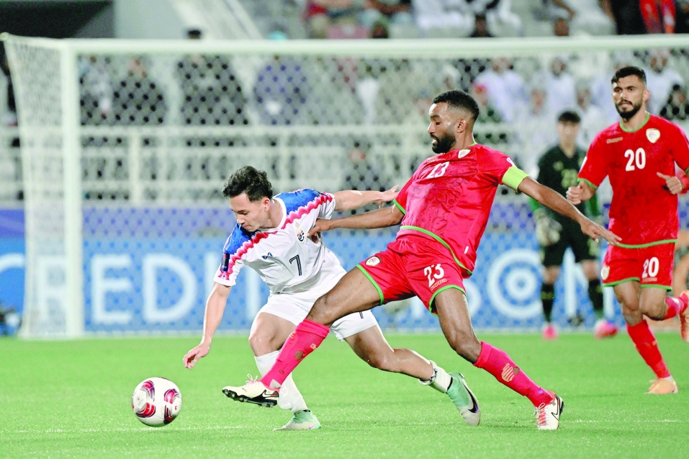 Thailand's midfielder #07 Supachok Sarachat and Oman's midfielder #23 Harib al Saadi vie for the ball during the Qatar 2023 AFC Asian Cup Group F football match between Oman and Thailand at the Abdullah bin Khalifa Stadium in Doha on January 21, 2024.