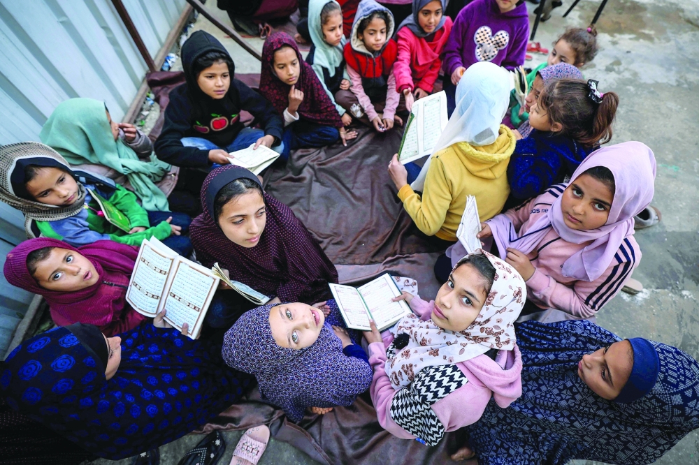 Displaced Palestinian children attend a Quran class at Bear al Saba school in Rafah in the southern Gaza Strip. - AFP

