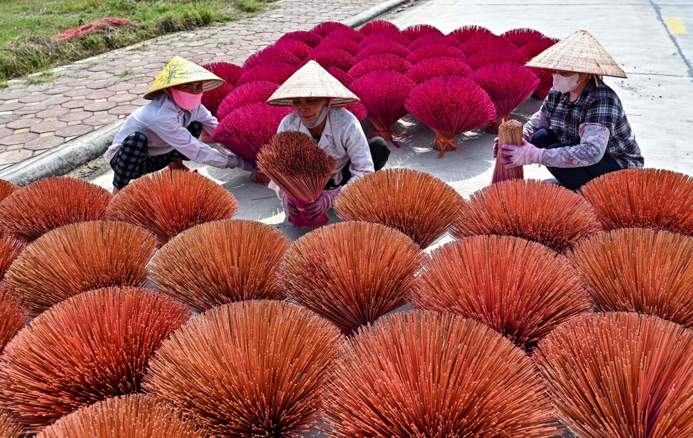 Wworkers prepare incense sticks in a courtyard in the village of Quang Phu Cau on the outskirts of Hanoi. - AFP

