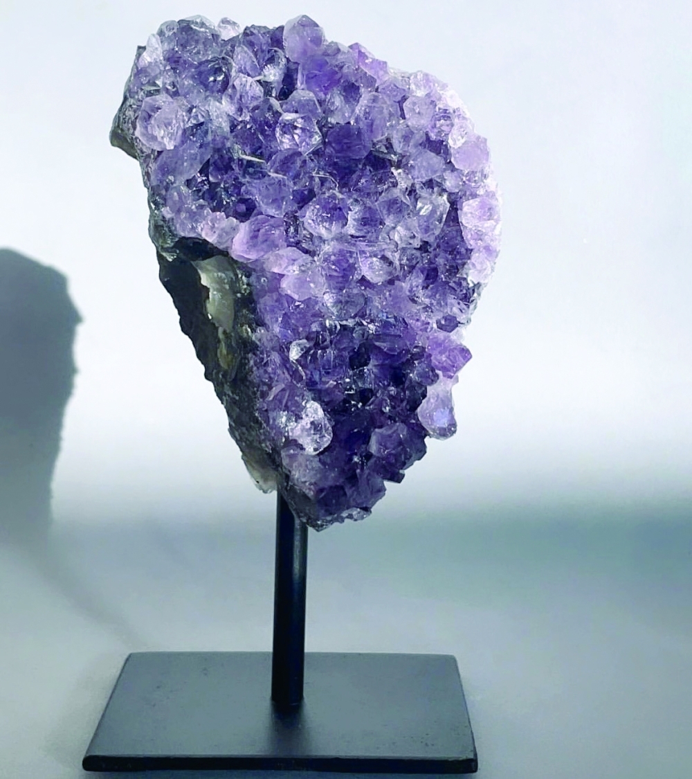 A natural amethyst on a metal stand