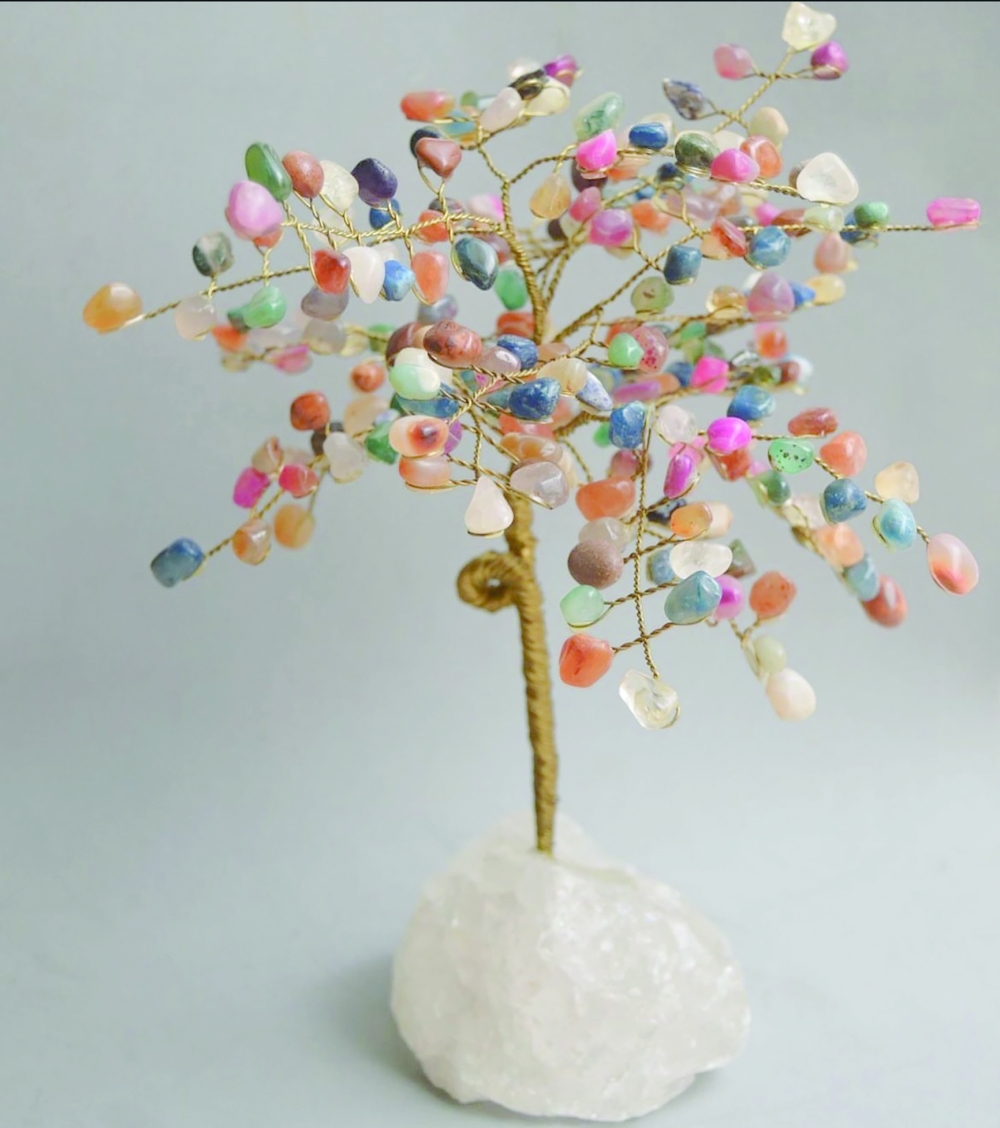 A tree base crafted from clear quartz, complemented by leaves made of multicolored agate