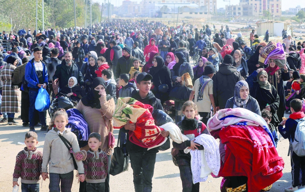 Palestinians carry some belongings as they flee Khan Yunis to safer areas further south in the southern Gaza Strip through the city's western exit on the outskirts of its refugee camp amid ongoing battles between Israel and Hamas