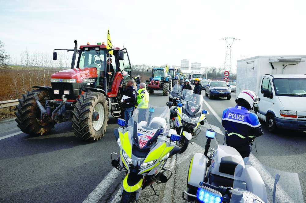 French farmers use their tractors during a go-slow operation near Roissy Charles-de-Gaulle airport as they protest over price pressures, taxes and green regulation, in Compans, near Paris. — Reuters