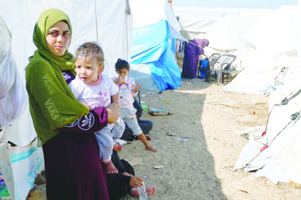Displaced Palestinians, who fled their houses amid Israeli strikes, take shelter at a United Nations-run centre, in Khan Younis. — Reuters file photo 