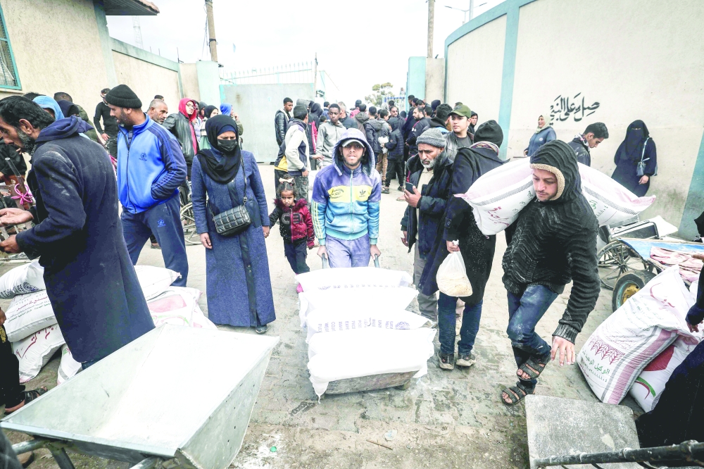 Displaced Palestinians receive food aid at the United Nations Relief and Works Agency for Palestine Refugees (UNRWA) centre in Rafah in the southern Gaza Strip. — AFP