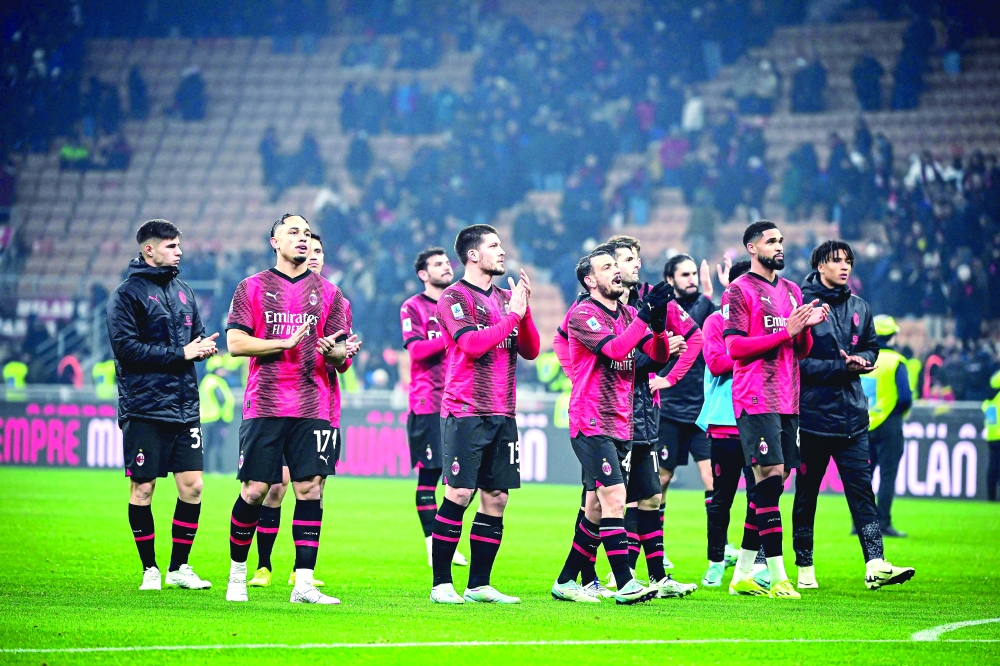 AC Milan's players greet their supporters at the end of the match. — AFP