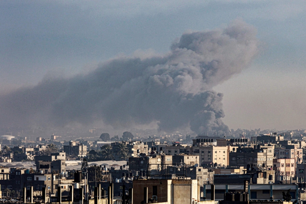 Smoke billow over buildings in Rafah in the southern Gaza Strip during Israeli bombardment on January 29, 2024