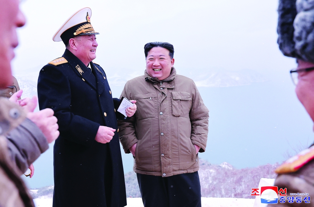 North Korean leader Kim Jong Un attends a submarine-launched cruise missile test with military officials at an undisclosed location in North Korea. — Reuters