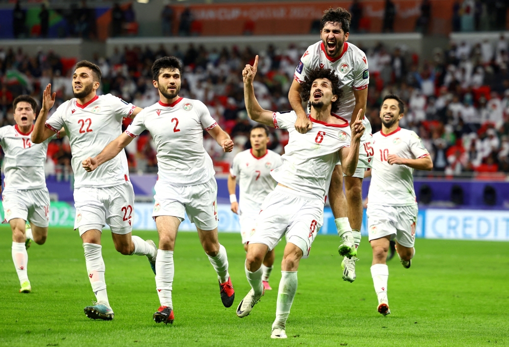 AFC Asian Cup - Round of 16 - Tajikistan v United Arab Emirates - Ahmad bin Ali Stadium, Al Rayyan, Qatar - January 28, 2024 Tajikistan's Vakhdat Khanonov celebrates scoring their first goal with teammates.