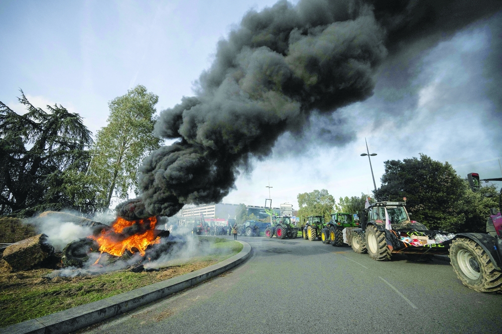 Farmers burn tyres, as tractors block the entrance of the Toulouse-Blagnac airport in Toulouse, southwestern France. — AFP