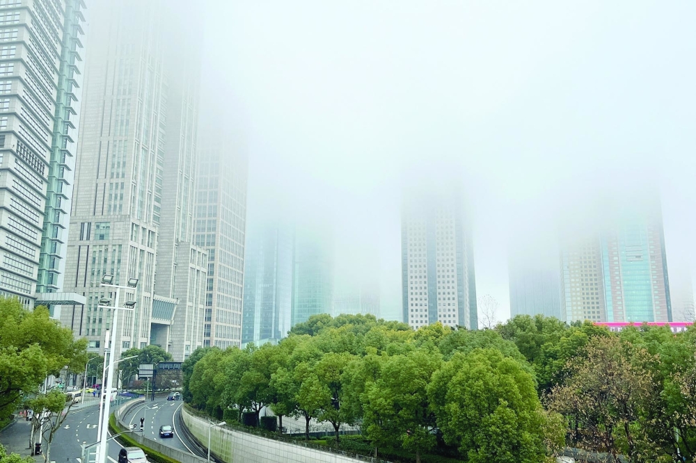 Buildings in Lujiazui financial district are seen shrouded in fog amid an orange alert for heavy fog in Shanghai, China. — Reuters