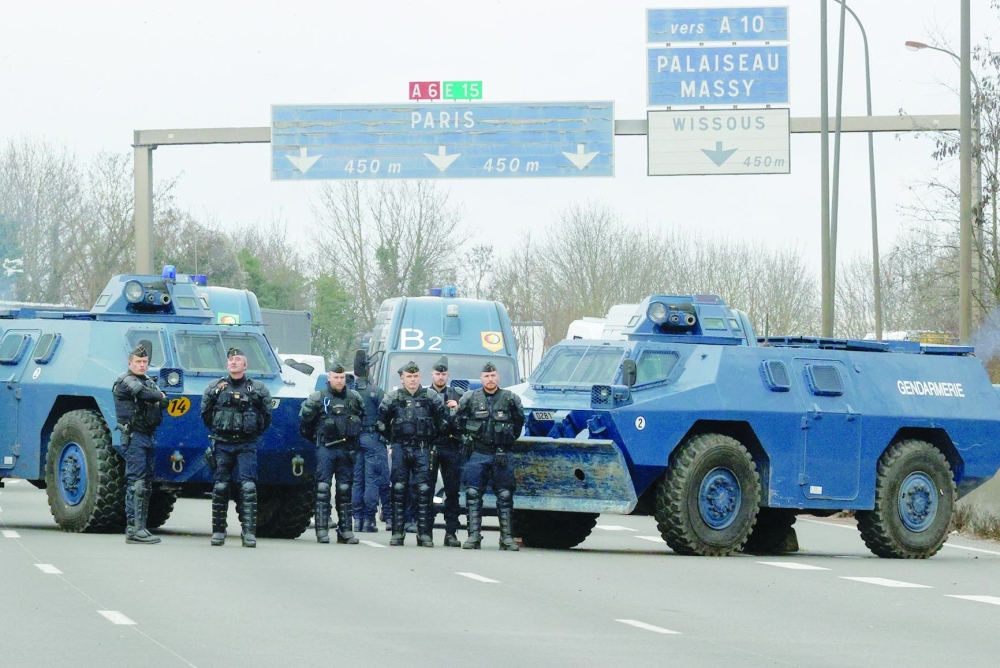 Members of the French Gendarmerie stand near armoured vehicles on the A6 highway, during farmer's protest, near Paris. — Reuters 