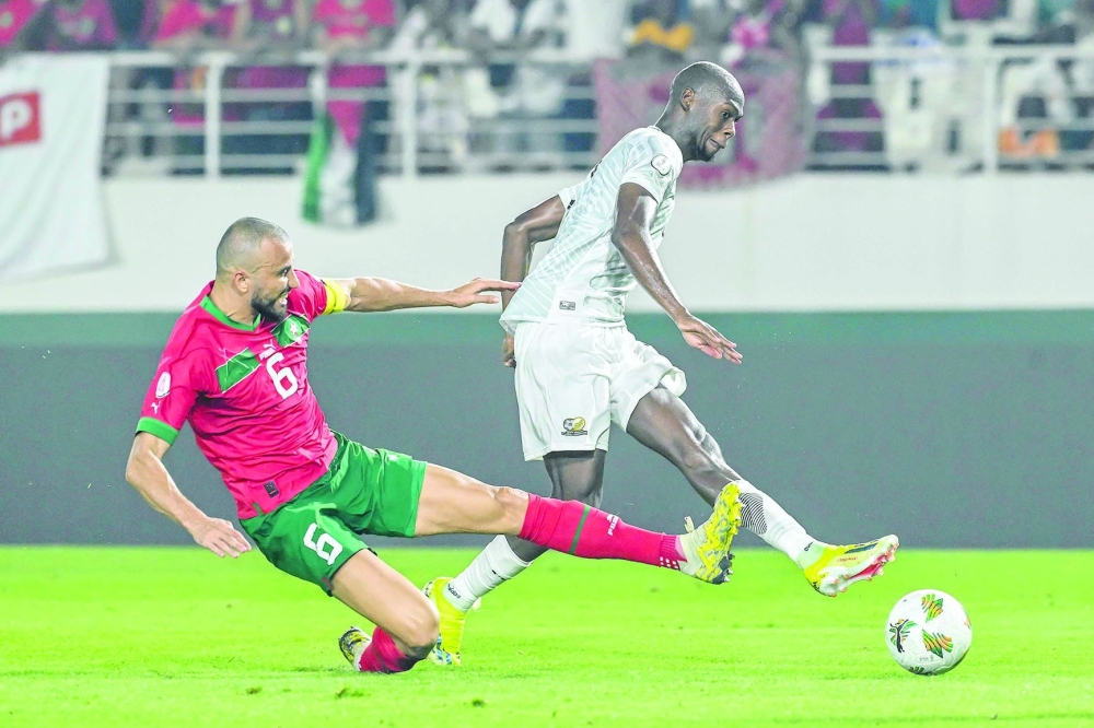 South Africa's forward #9 Evidence Makgopa (R) shoots the ball to score a goal as Morocco's defender #6 Romain Saiss (L) tries to stop him during the Africa Cup of Nations (CAN) 2024 round of 16 football match between Morocco and South Africa at the Stade Laurent Pokou in San Pedro on January 30, 2024. (Photo by SIA KAMBOU / AFP)