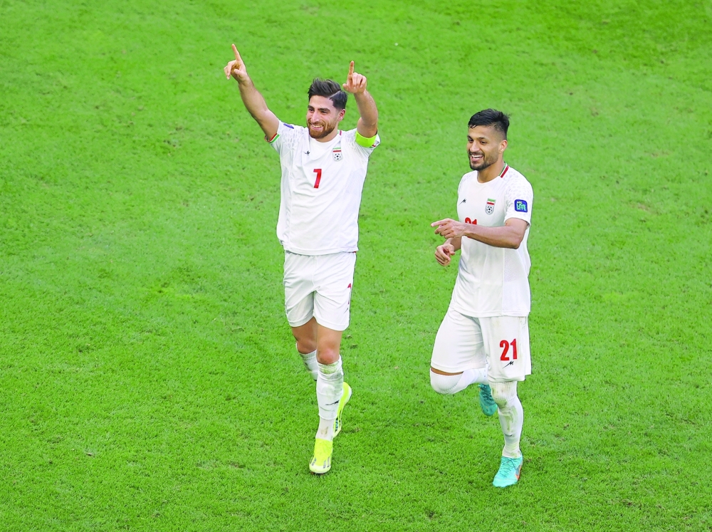 Iran's Alireza Jahanbakhsh celebrates scoring their second goal with Mohammad Mohebbi. — REUTERS