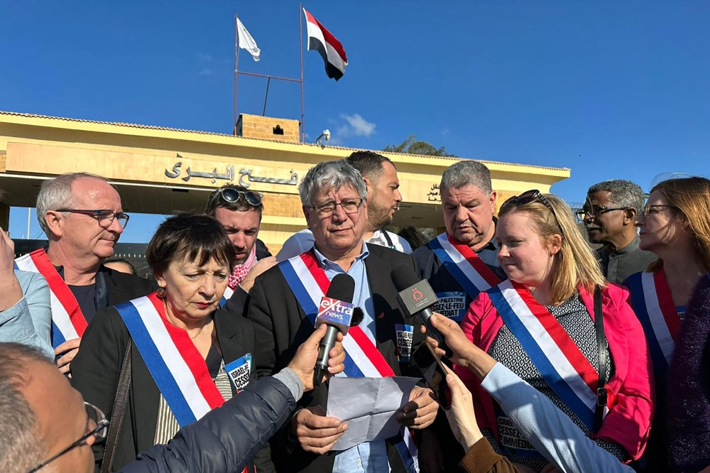 French member of parliament Eric Coquerel (C) reads a statement by a delegation of French parliamentarians demanding a ceasefire, during a visit to the Egyptian side of the Rafah border crossing with the Gaza Strip. — AFP 