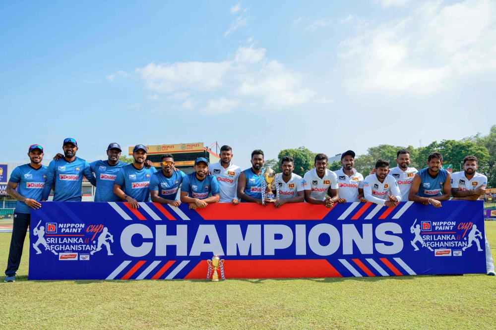 Sri Lankan players pose with the series trophy after their victory at the one-off Test cricket match between Sri Lanka and Afghanistan at the Sinhalese Sports Club (SSC) in Colombo on February 5, 2024.  (Photo by Ishara S. KODIKARA / AFP)