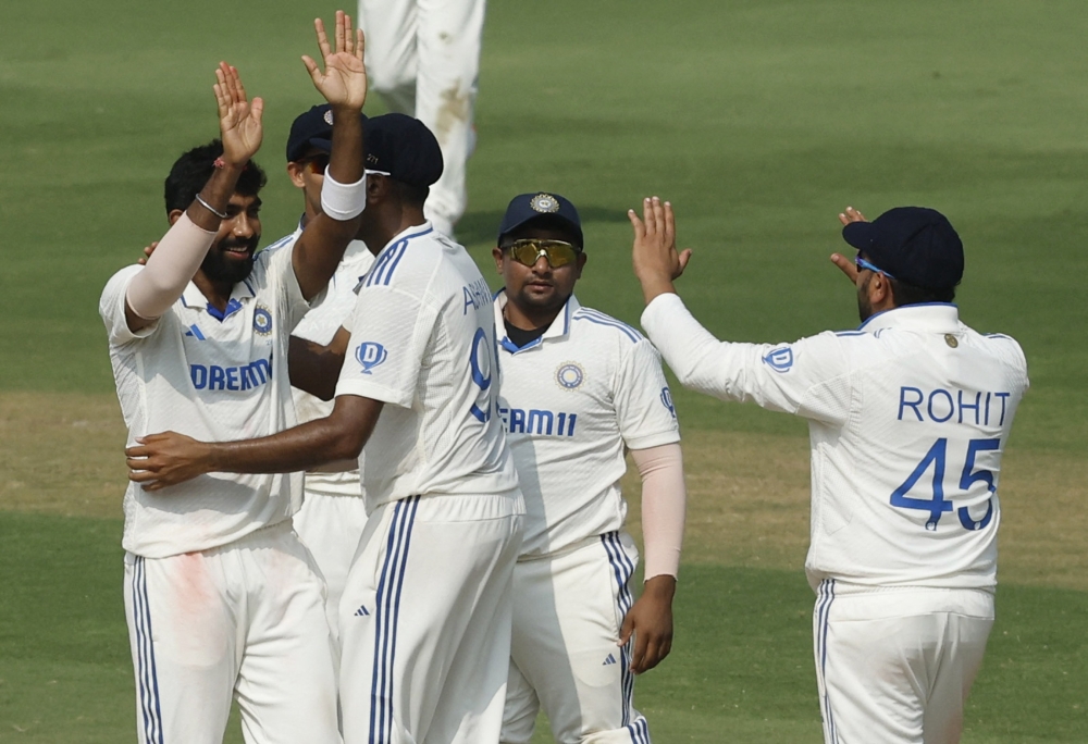 Cricket - Second Test - India v England - Dr. Y.S. Rajasekhara Reddy ACA-VDCA Cricket Stadium, Visakhapatnam, India - February 5, 2024 India's Jasprit Bumrah celebrates with Rohit Sharma and teammates after taking the wicket of England's Tom Hartley to win the second Test REUTERS/Francis Mascarenhas
