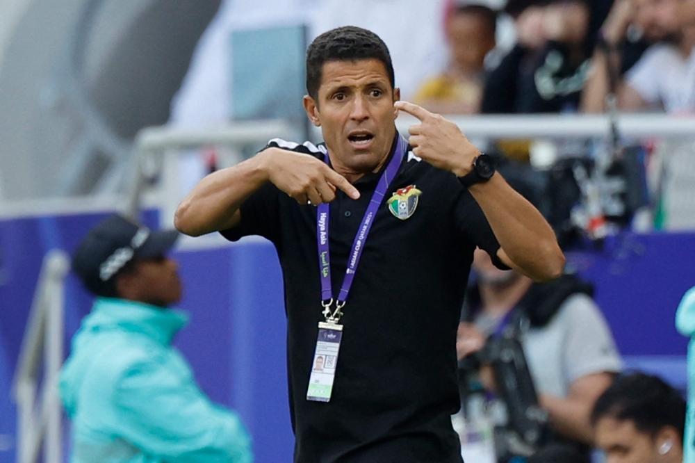 Jordan's Moroccan coach Hussein Ammouta speaks to his players during the Qatar 2023 AFC Asian Cup quarter-final football match between Tajikistan and Jordan at the Ahmad Bin Ali Stadium in Al-Rayyan, west of Doha on February 2, 2024. 