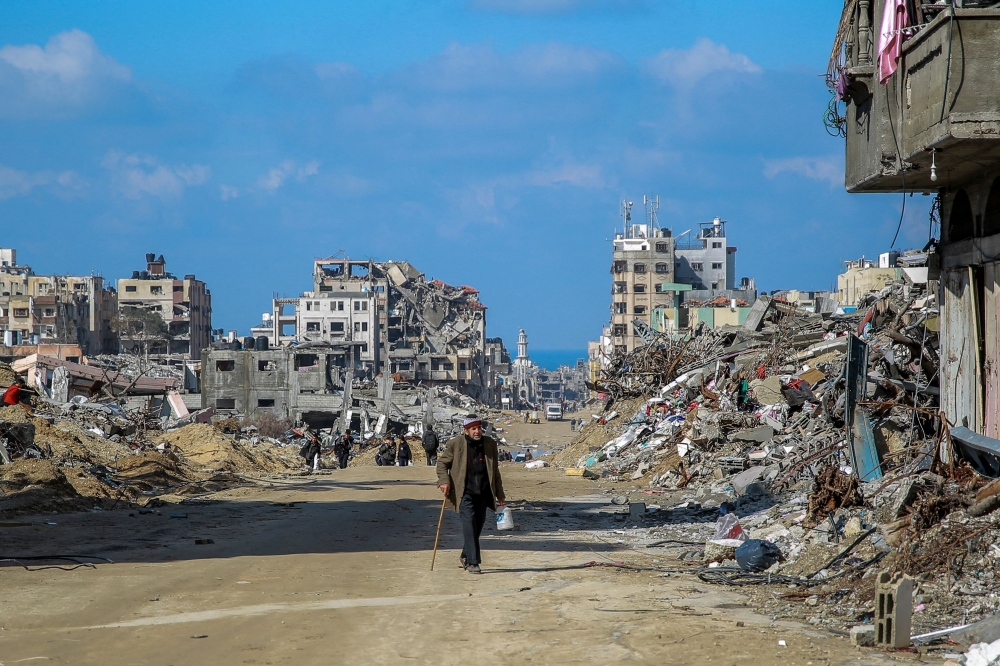 People walk on Al Oyoun Street amid the rubble of buildings destroyed during Israeli bombardment on Gaza City. — AFP