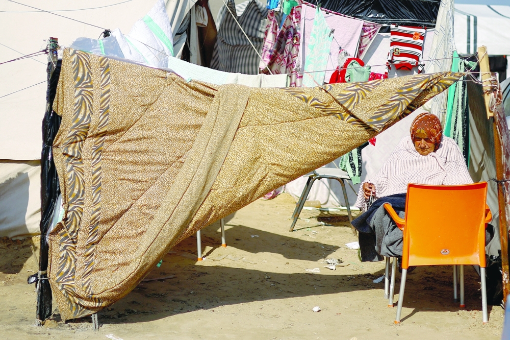 An elderly woman sits outside a tent as displaced Palestinians take shelter in a tent camp in Rafah. — Reuters 