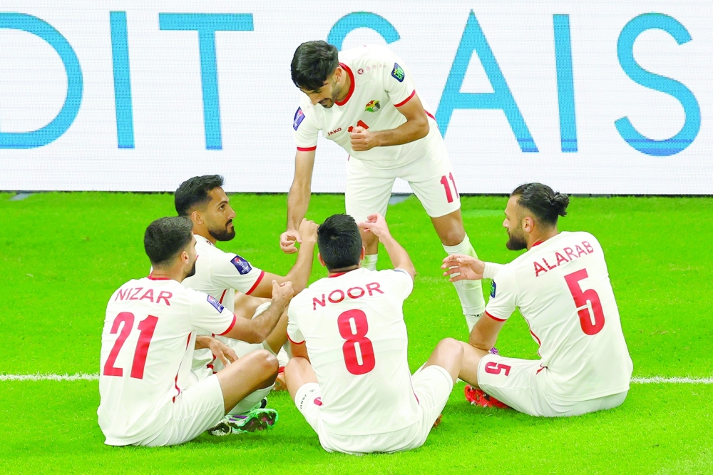 Jordan's forward #11 Yazan al-Naimat celebrates with teammates after scoring a goal during the Qatar 2023 AFC Asian Cup semi-final football match between Jordan and South Korea at the Ahmad Bin Ali Stadium in Al-Rayyan, west of Doha on February 6, 2024.
