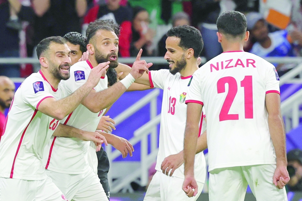 Jordan's midfielder #10 Musa al-Tamari celebrates with teammates after scoring their second goal during the Qatar 2023 AFC Asian Cup semi-final football match between Jordan and South Korea at the Ahmad Bin Ali Stadium in Al-Rayyan, west of Doha on February 6, 2024.
