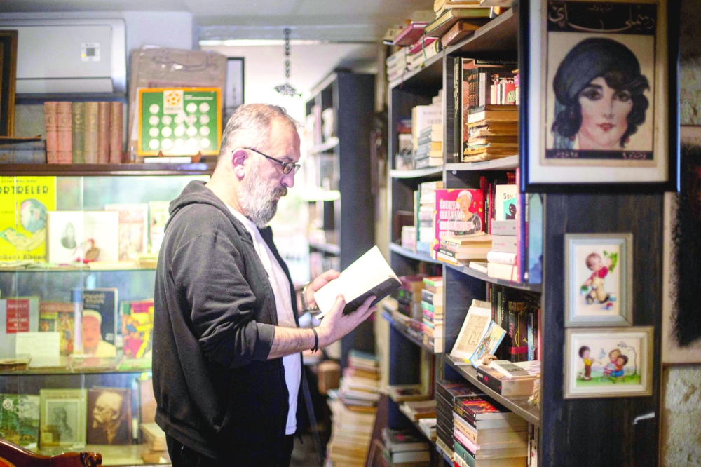 Umit Nar, owner of the Hermes bookshop, reads a book in Izmir, on February 6, 2014. Umit Nar, a bookseller in the western city of Izmir, is being sued by the French luxury brand Herm鑚, which wants to prevent him from using the name of the Greek god for his shop. Umit Nar, who owns the Sahaf Hermes store in the Aegean coast city of Izmir, argues that he has been in business for 15 years and never once been mistaken for a French luxury goods maker.