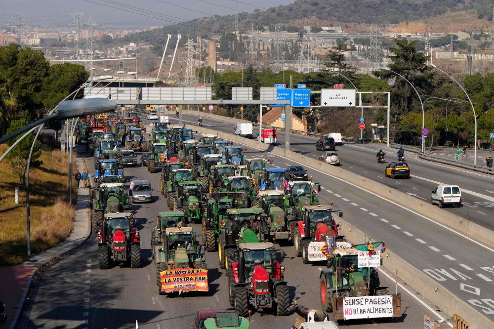 Tractors drive during a protest on the highway north of Barcelona. — AFP