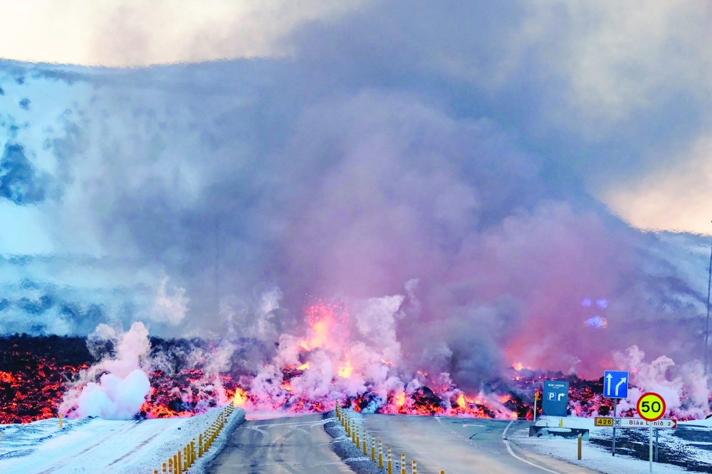 Molten lava is seen overflowing the road leading to the famous tourist destination 'Blue Lagoon' near Grindavik, western Iceland. - AFP 